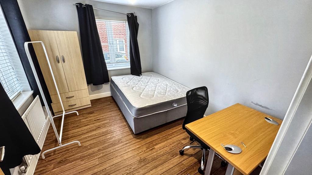 Bright, simply furnished bedroom with a comfort...