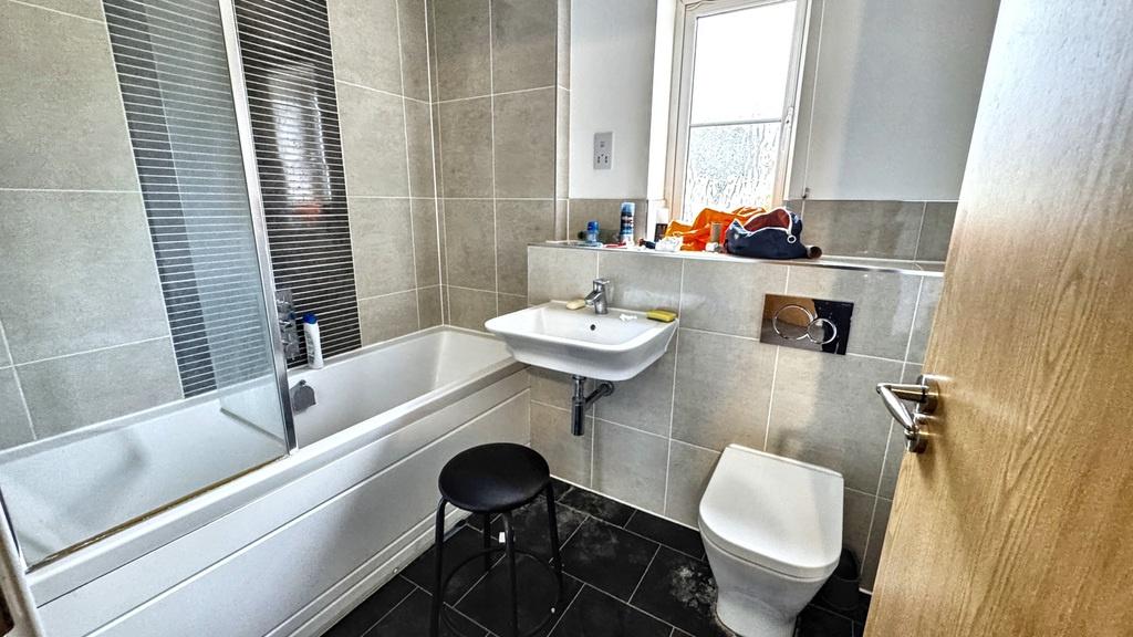 Bright modern bathroom with a white bathtub, wa...