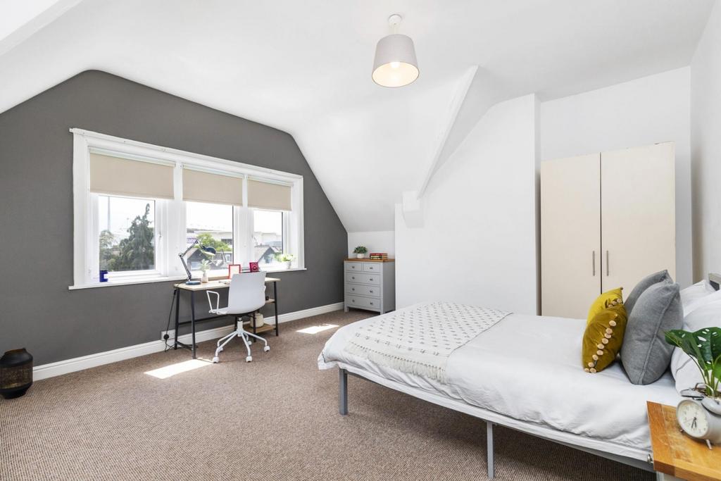 A spacious and well-lit master bedroom featurin...