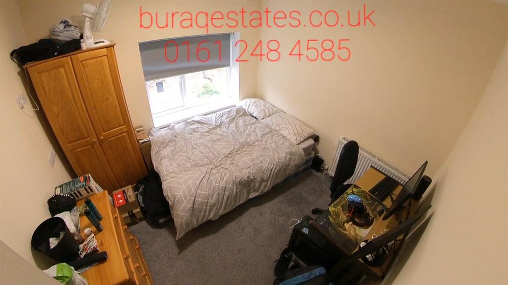 Neat, simply furnished bedroom with a comfortab...