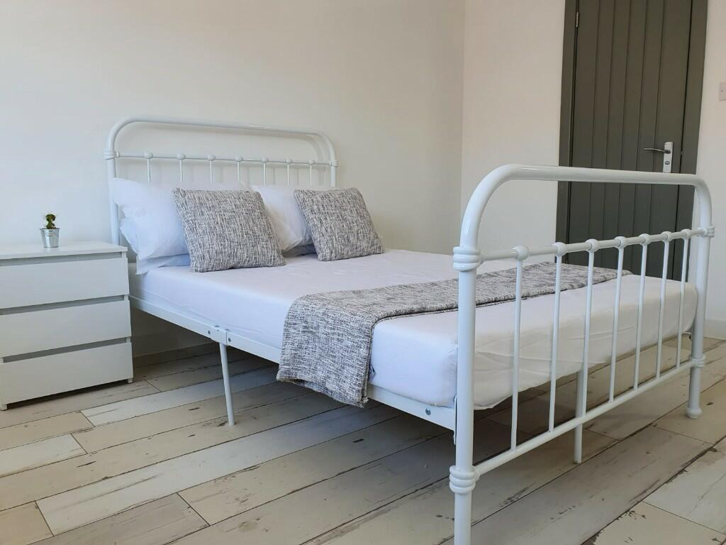 A bright and neatly arranged small bedroom feat...
