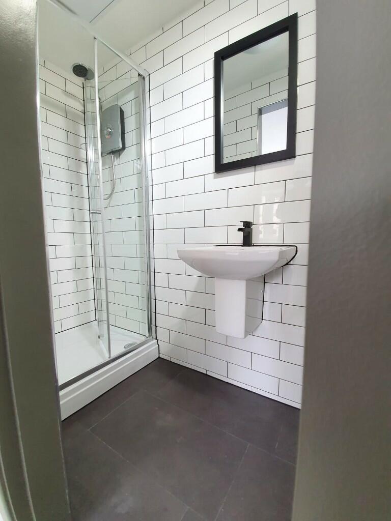 A modern compact bathroom with white subway til...