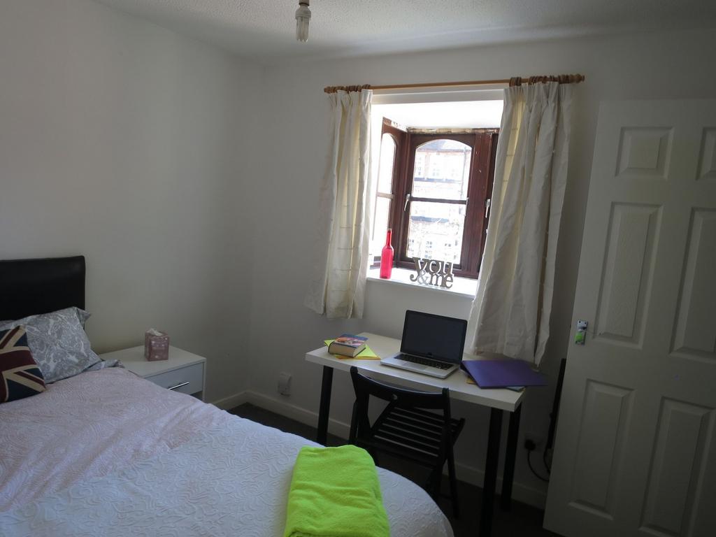 A cozy bedroom featuring a neatly made bed, a w...