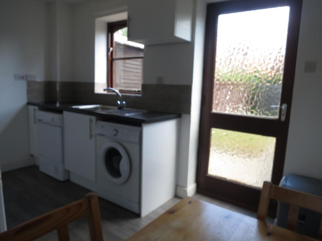 A compact kitchen area featuring a washing mach...