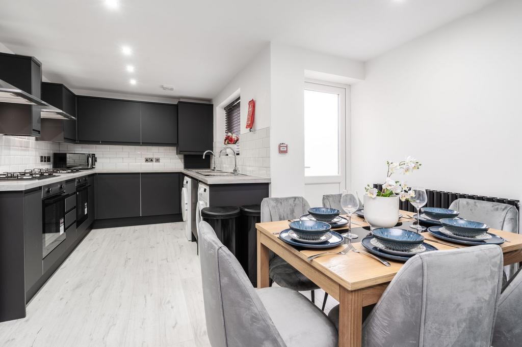 Modern kitchen with sleek black cabinets, ample...