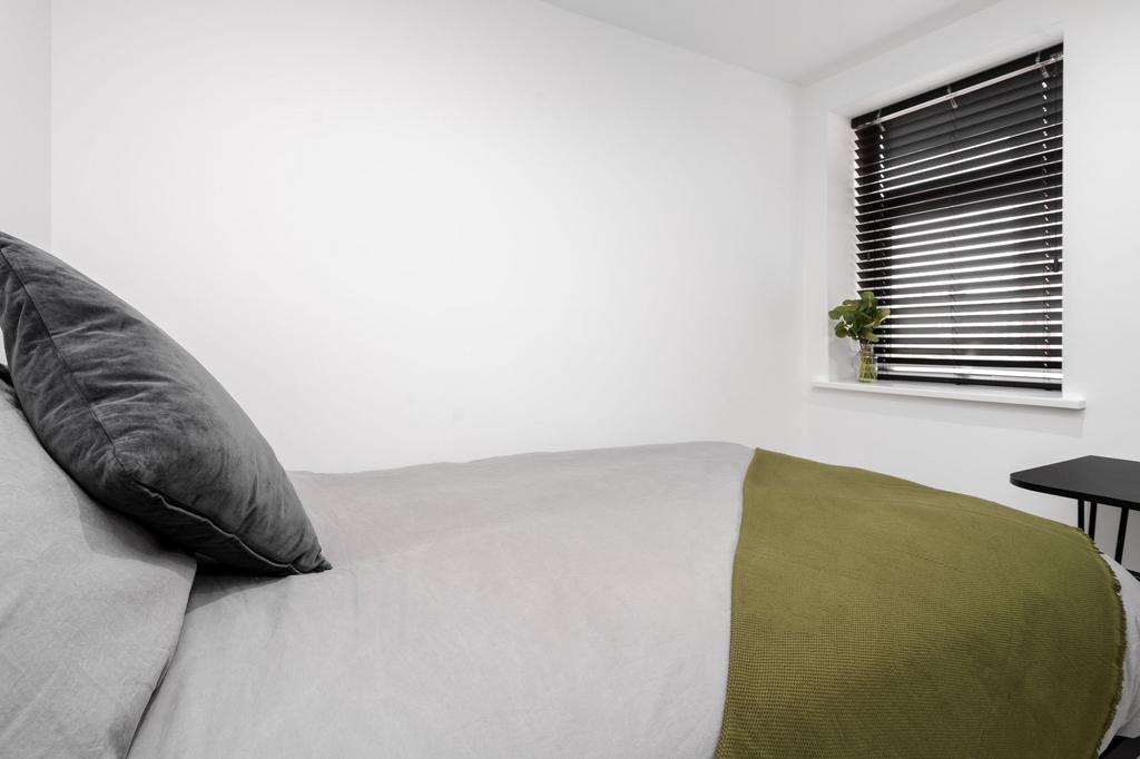 A bright and minimalist bedroom featuring a com...