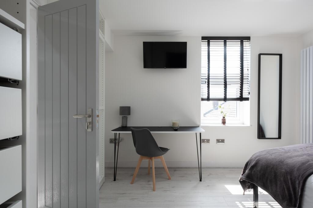Bright and modern master bedroom featuring a st...