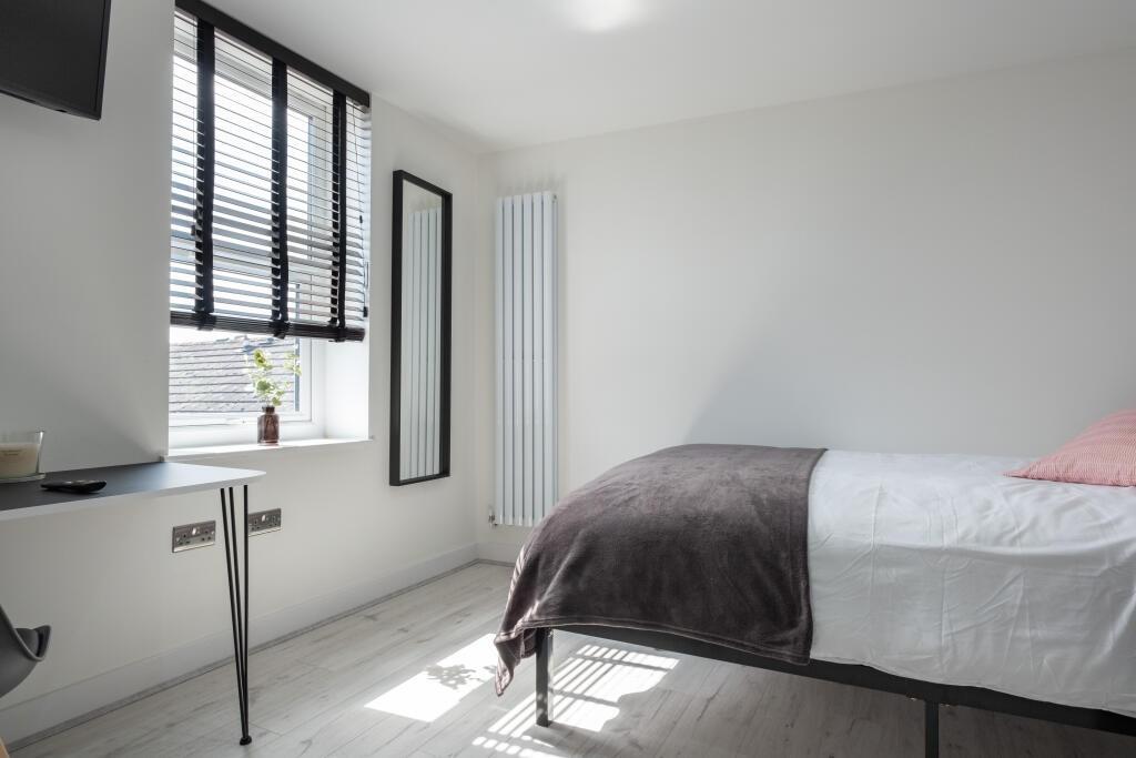 Bright and airy master bedroom featuring a larg...