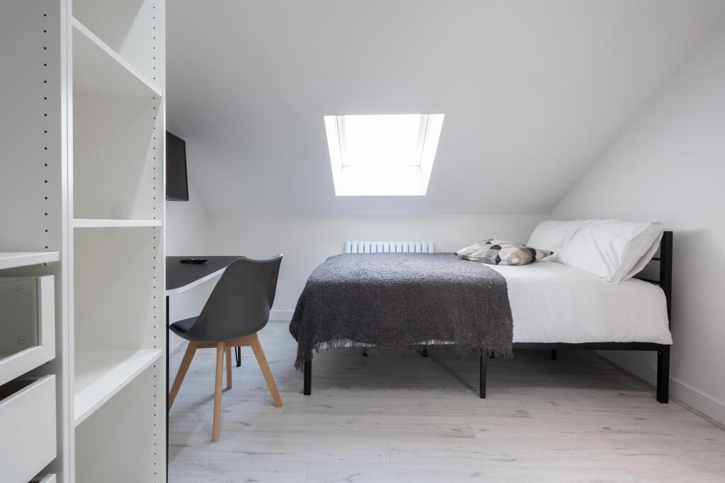 Bright and clean single bedroom with a skylight...