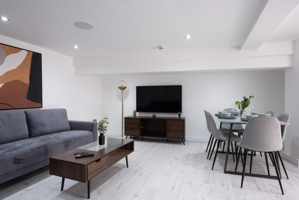 A stylish and contemporary living room featurin...
