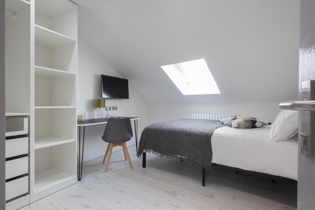A bright and tidy single bedroom featuring a ne...