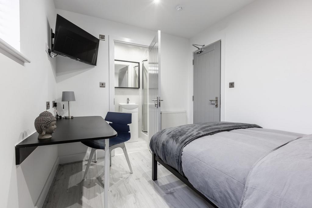 A modern, well-lit bedroom featuring a comforta...