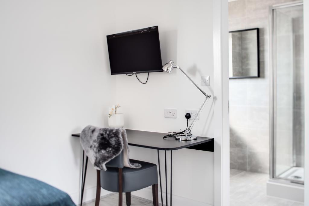 A small, tidy bathroom featuring a toilet, with...