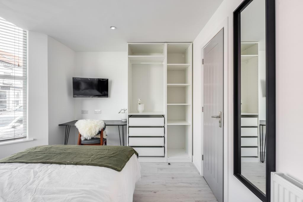 Bright and modern bedroom featuring a double be...