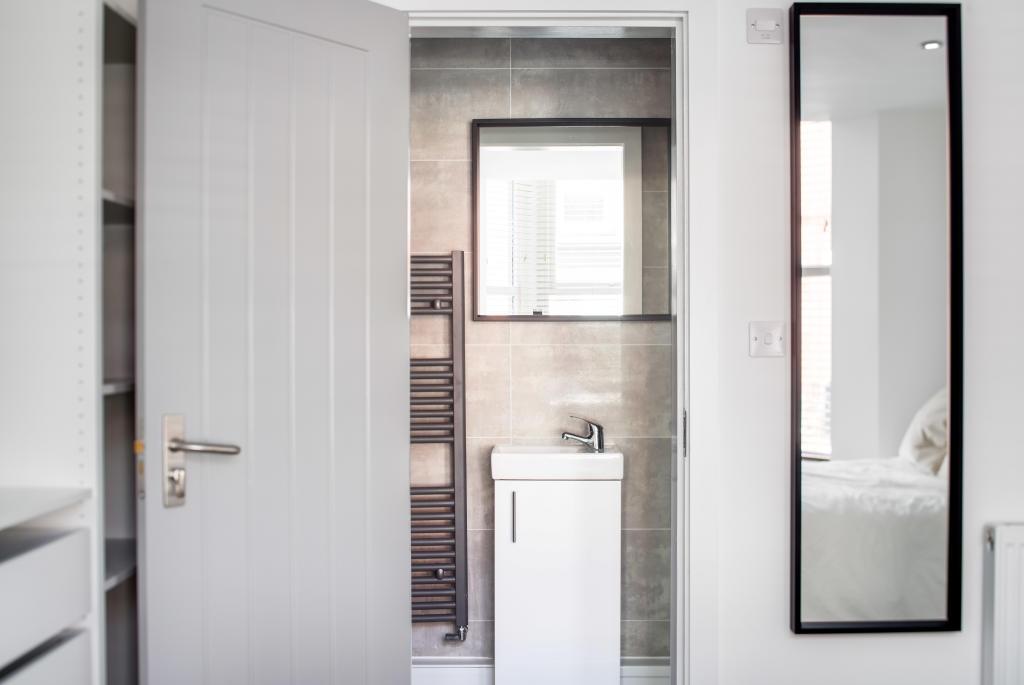 A modern bathroom with a sink and mirror, featu...