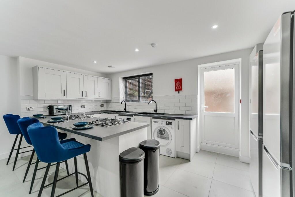 Modern and bright kitchen featuring white cabin...