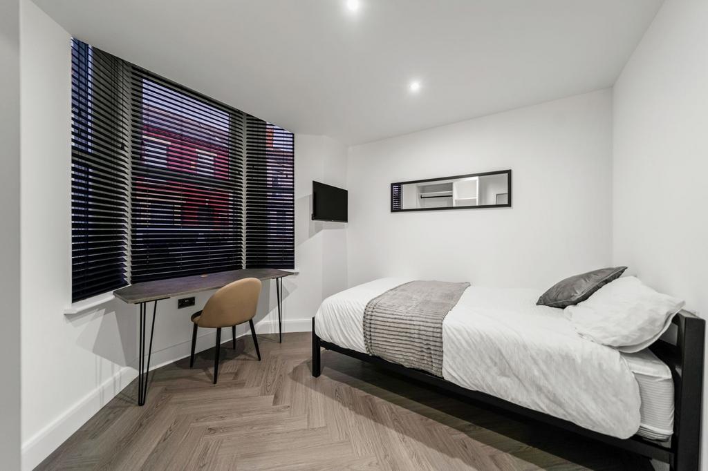A bright and modern bedroom featuring a comfort...