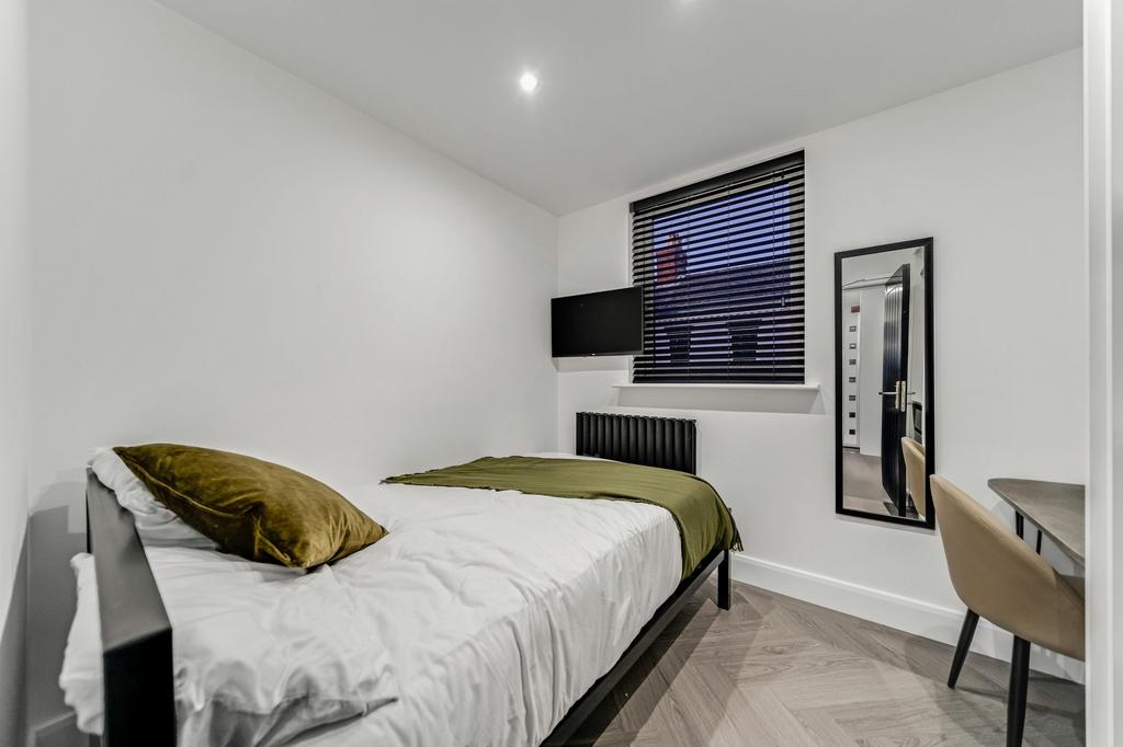 A modern and minimalistic bedroom with a cozy b...