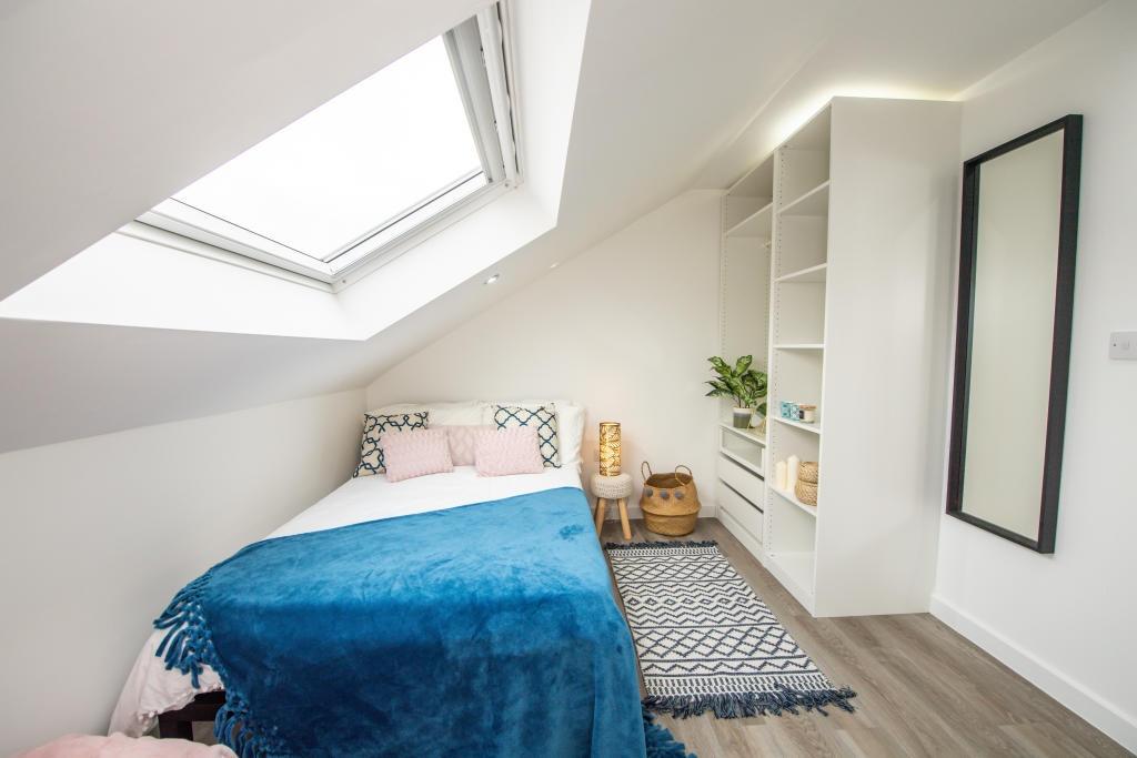 A bright and welcoming double bedroom featuring...