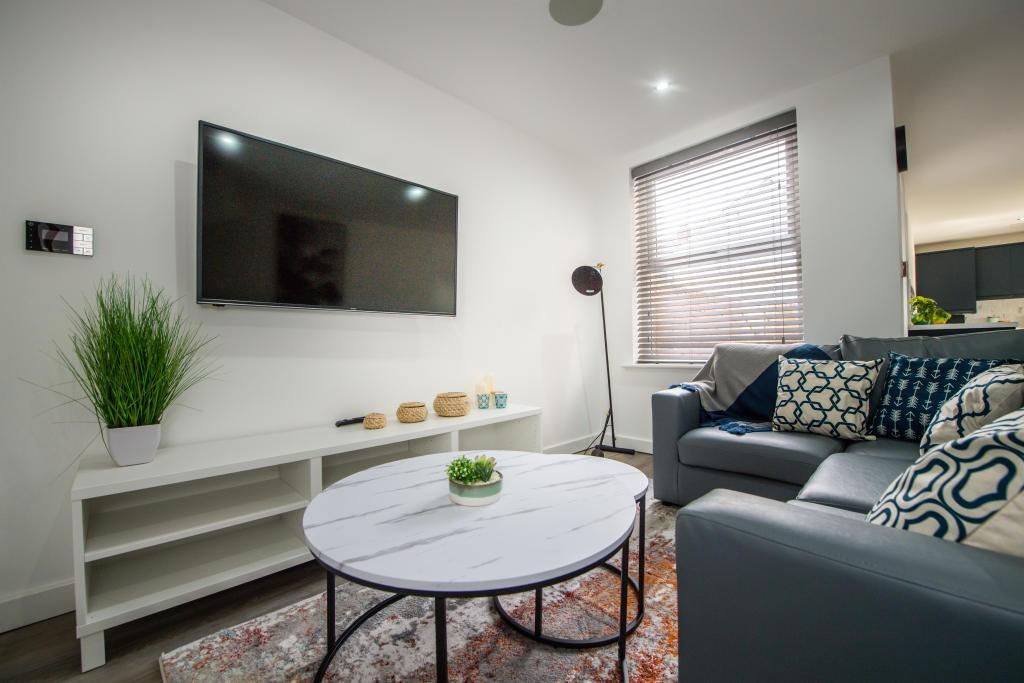 A bright and contemporary living room featuring...