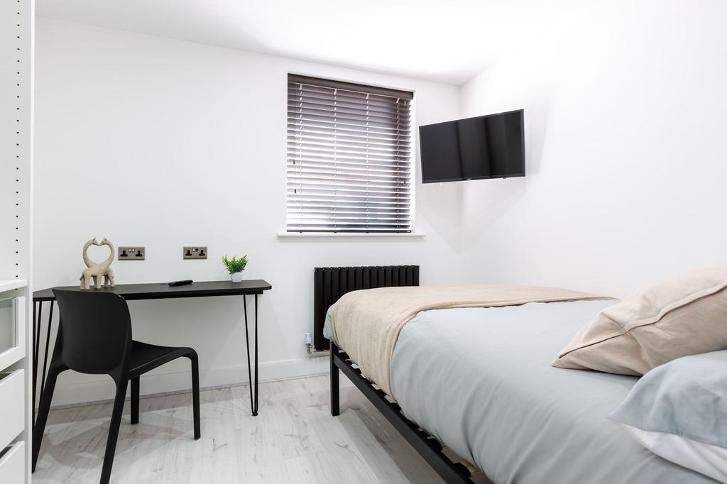 A bright, minimalist master bedroom featuring a...