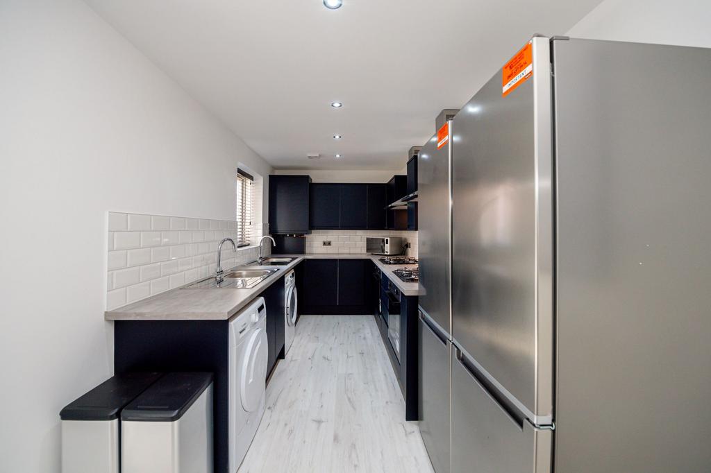 Modern kitchen featuring sleek black cabinetry,...