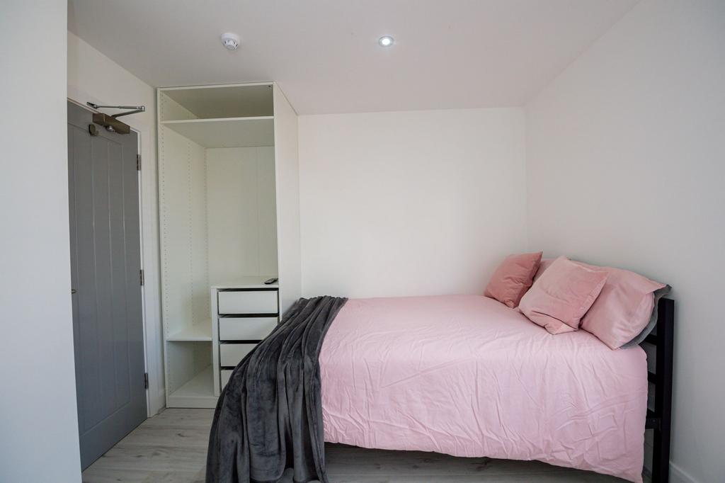 A comfortably furnished single bedroom featurin...