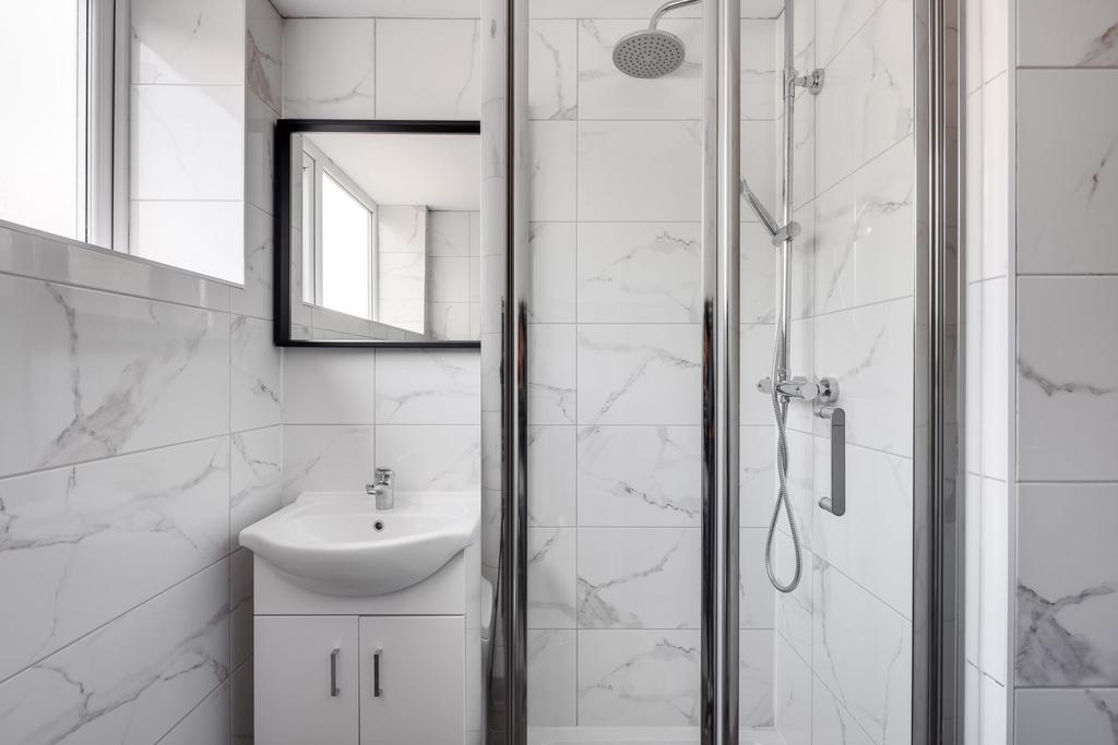 A modern and clean bathroom with white marble t...