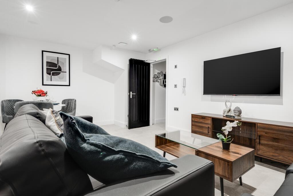 A modern, well-lit living room featuring a slee...