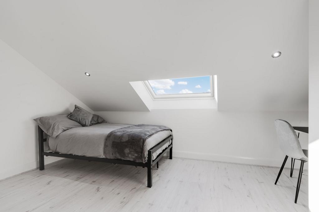 Bright and modern bedroom featuring a double be...