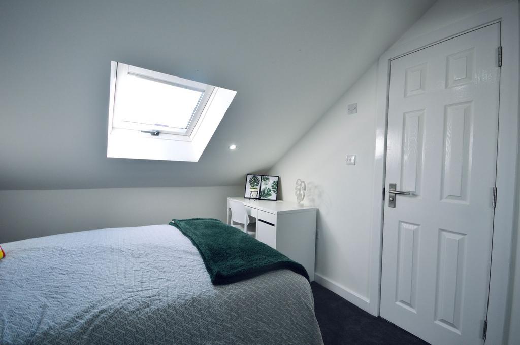 Bright, modern bedroom featuring a skylight win...