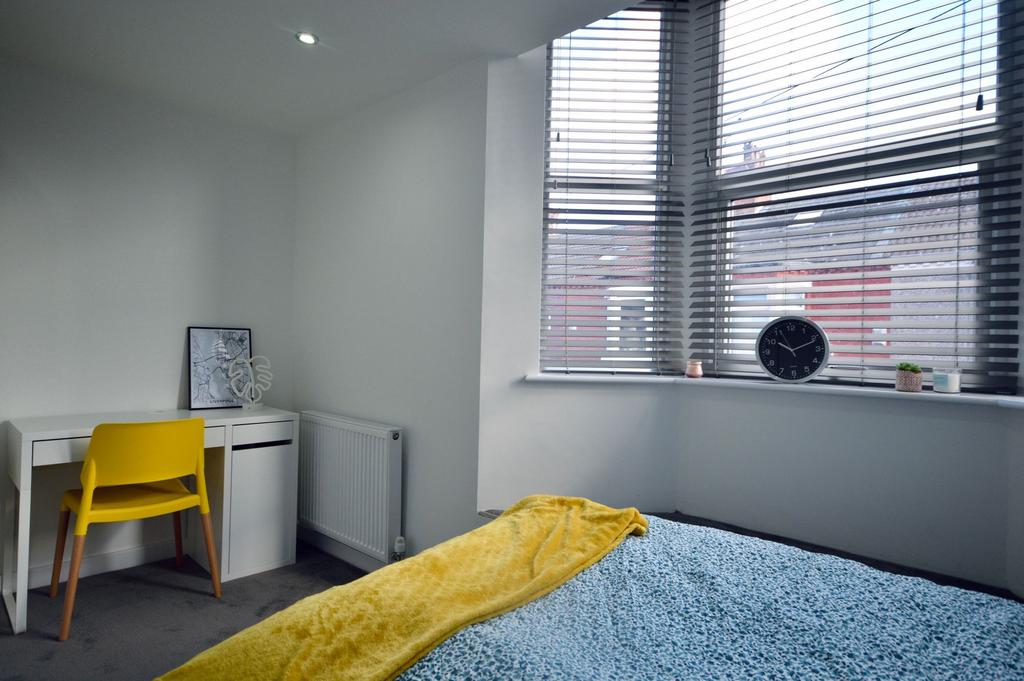 A bright, modern bedroom featuring a large wind...