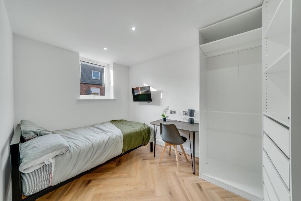 A bright and tidy bedroom featuring a single be...