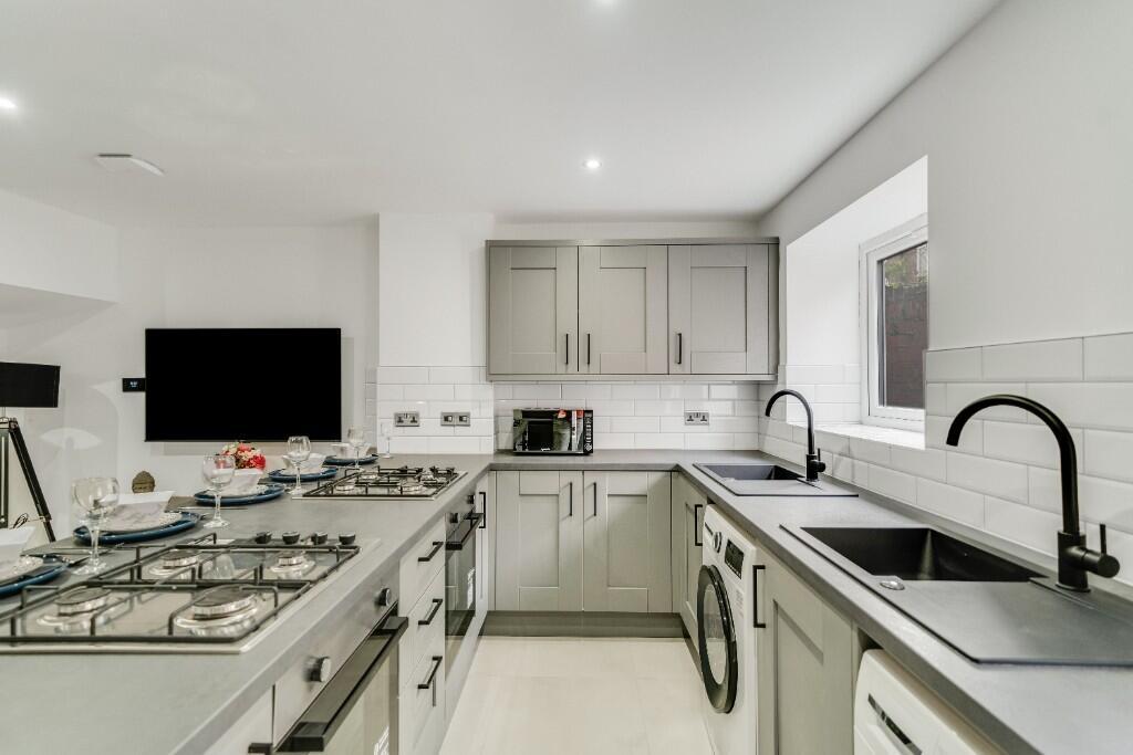 Modern and well-lit kitchen with sleek cabinetr...
