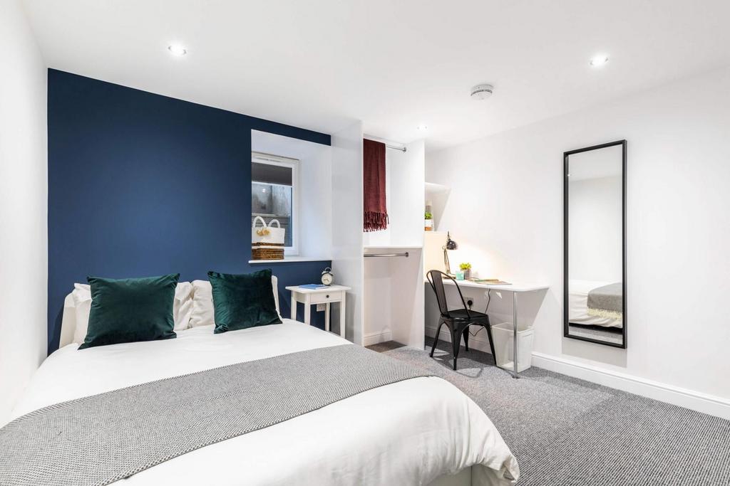 Bright, modern double bedroom with a comfortabl...