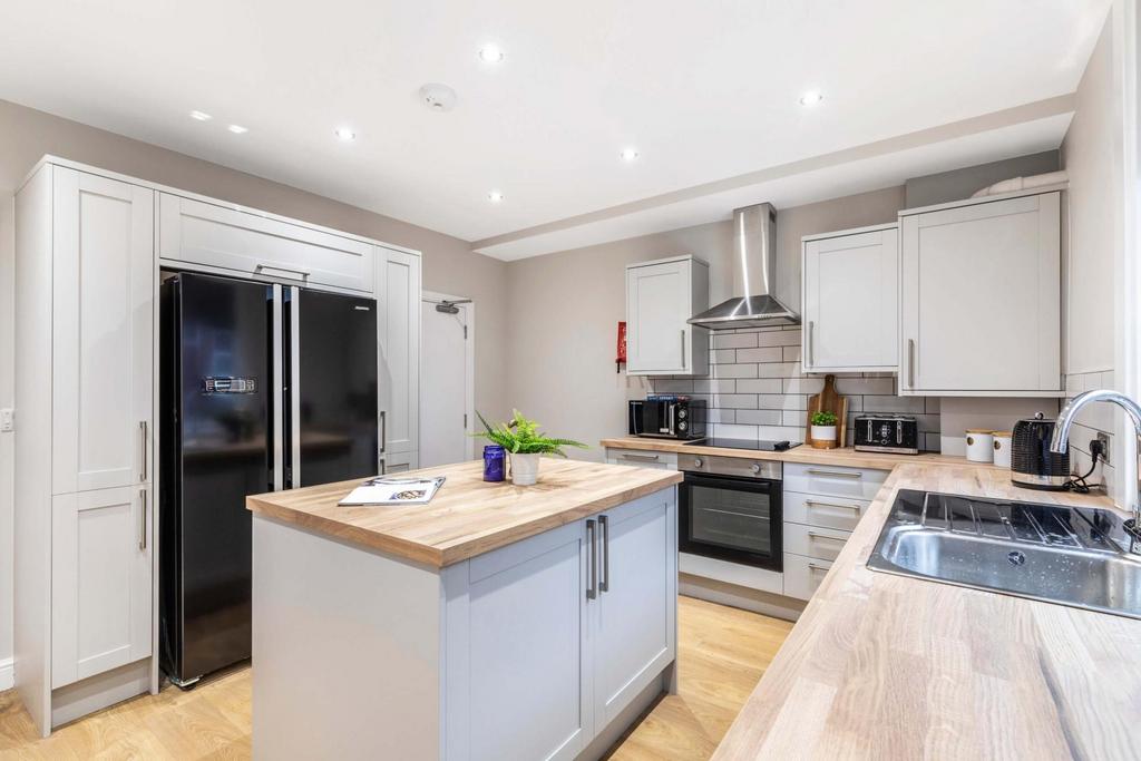 Bright, modern kitchen with central island, int...
