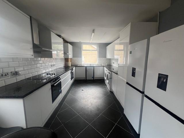 Bright, modern kitchen with sleek white cabinet...