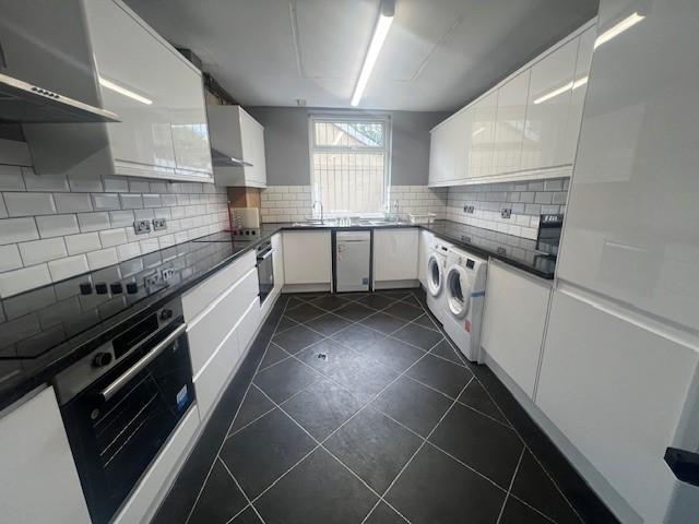 Modern galley kitchen with glossy white cabinet...