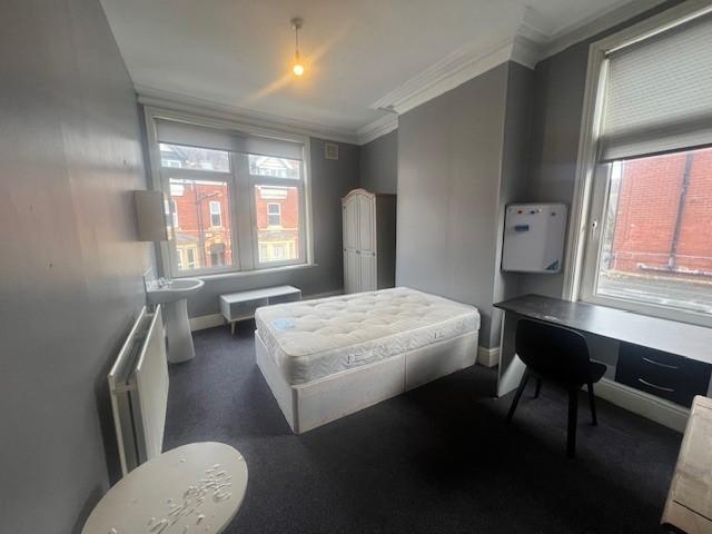 Bright, neutrally decorated bedroom with a doub...