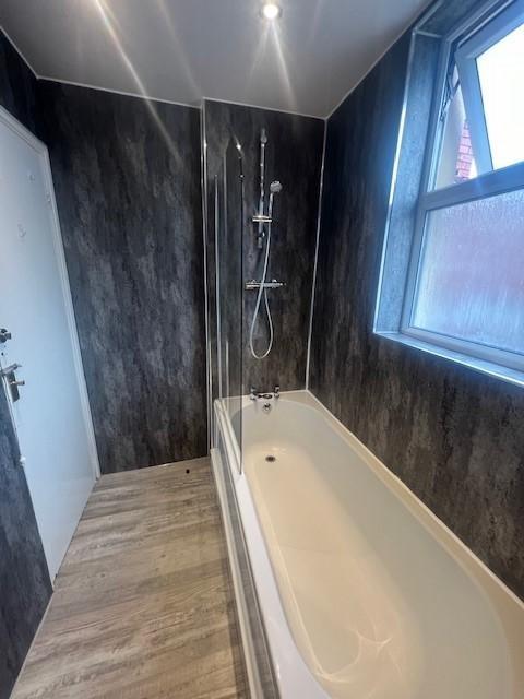 Modern bathroom with a full-size bathtub and se...