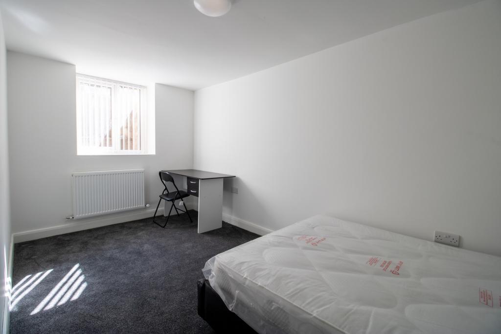 Bright, simply furnished double bedroom with a ...