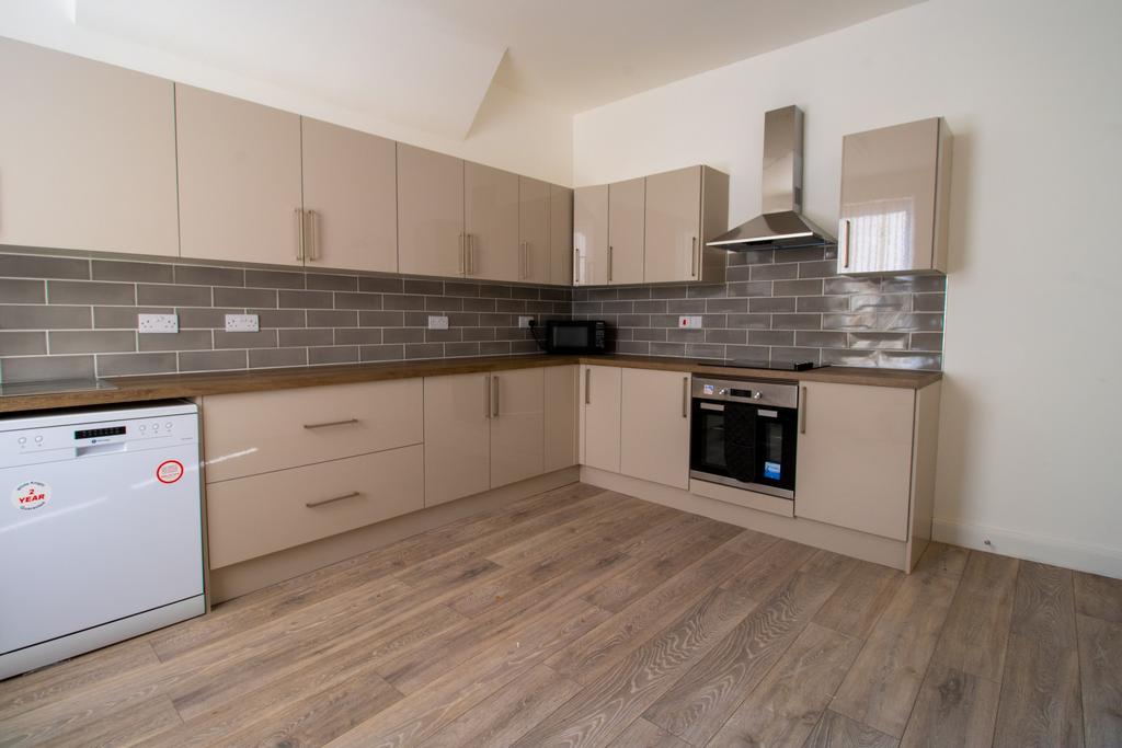 Modern fitted kitchen with sleek beige cabinetr...