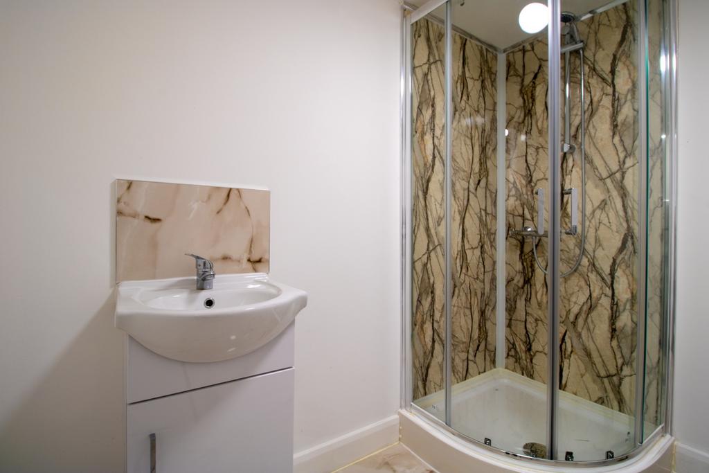 Modern bathroom with a corner glass shower encl...