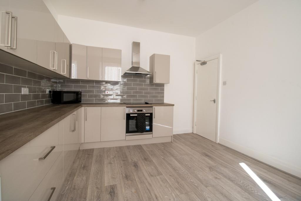 Modern fitted kitchen with grey subway tile spl...