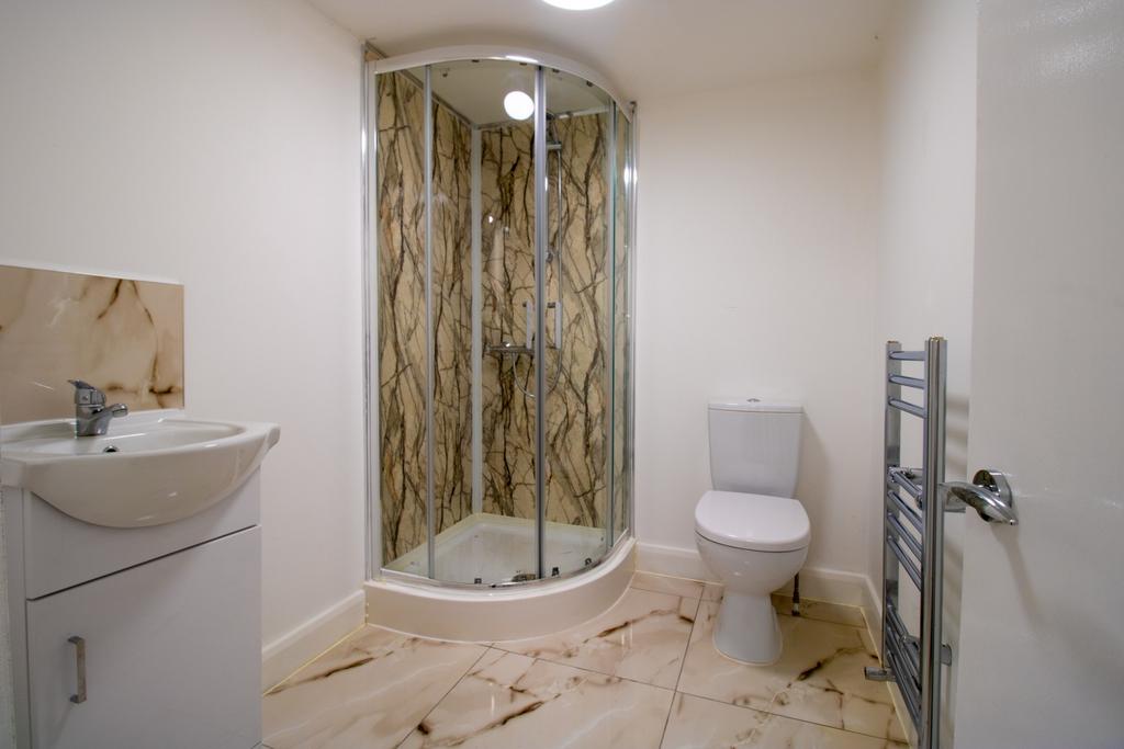 Bright, modern bathroom with a corner glass sho...