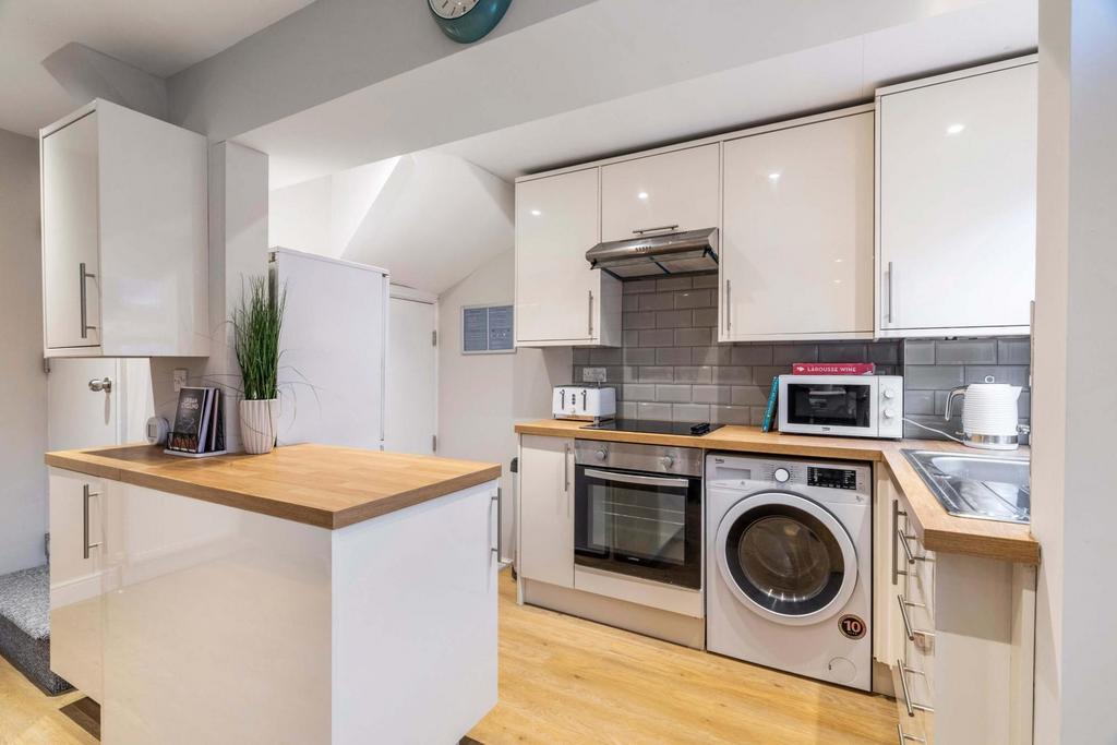 Bright modern kitchen with white high-gloss cab...