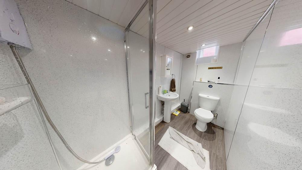 Bright, modern bathroom with a glass-enclosed s...