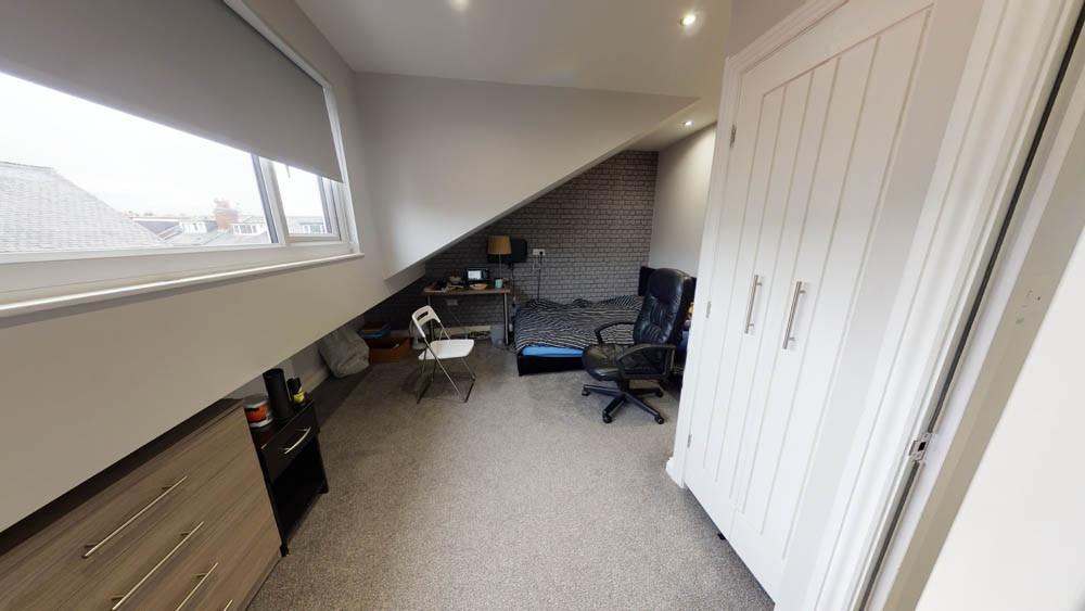Bright upstairs single bedroom with a sloped ce...