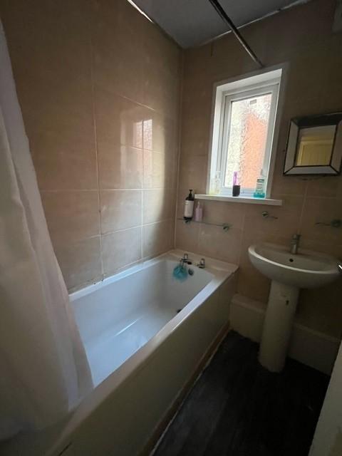 Bright bathroom with a built-in bath, pedestal ...