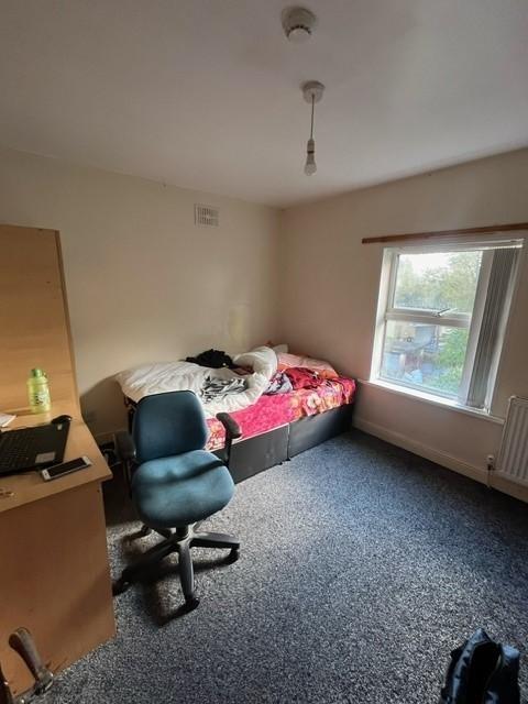 Bright single bedroom with a large window, fitt...